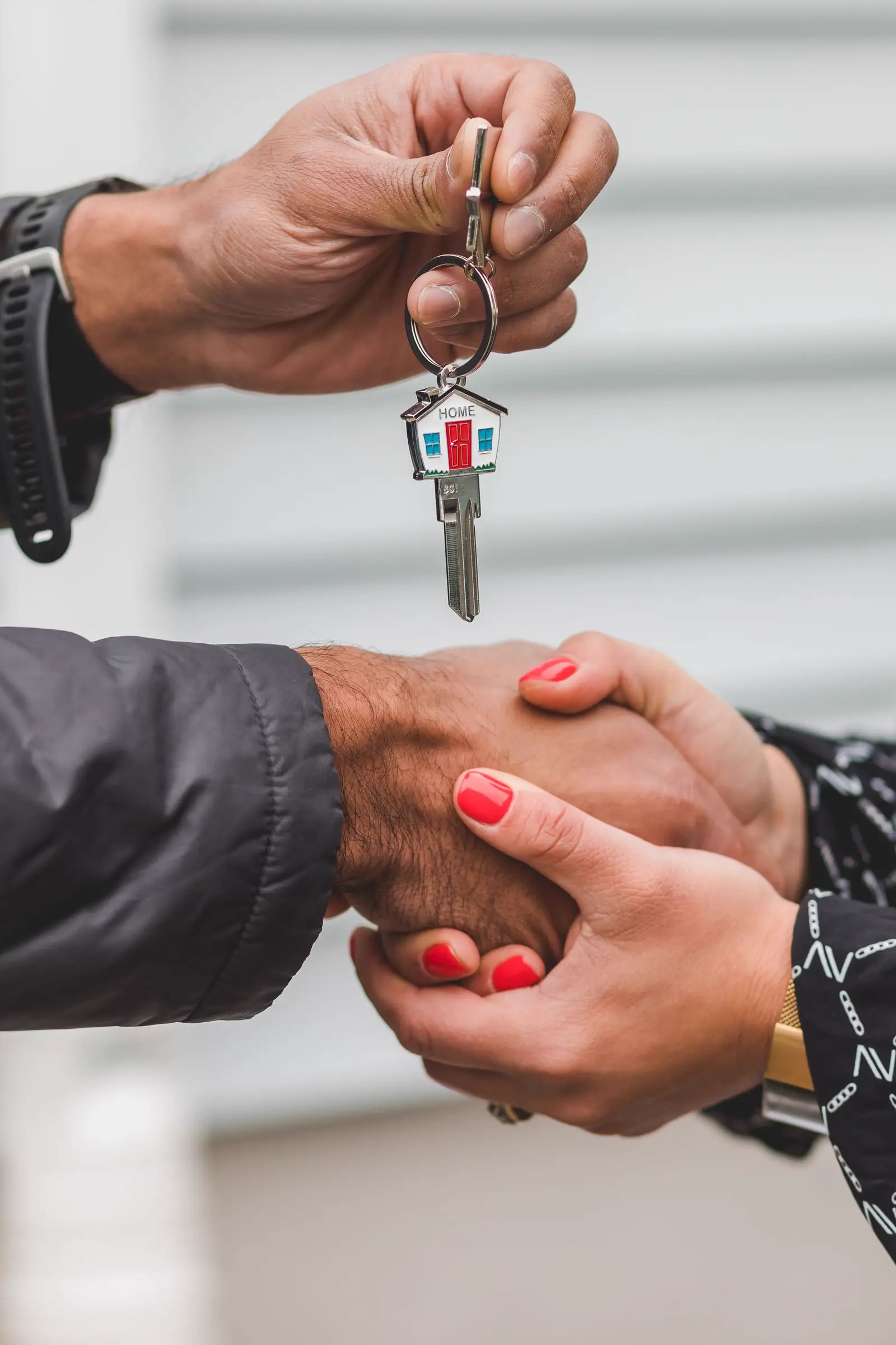 A handshake with a house key at a loan signing