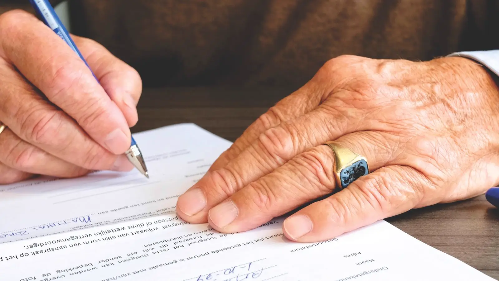 A hand with a pen signing a legal document