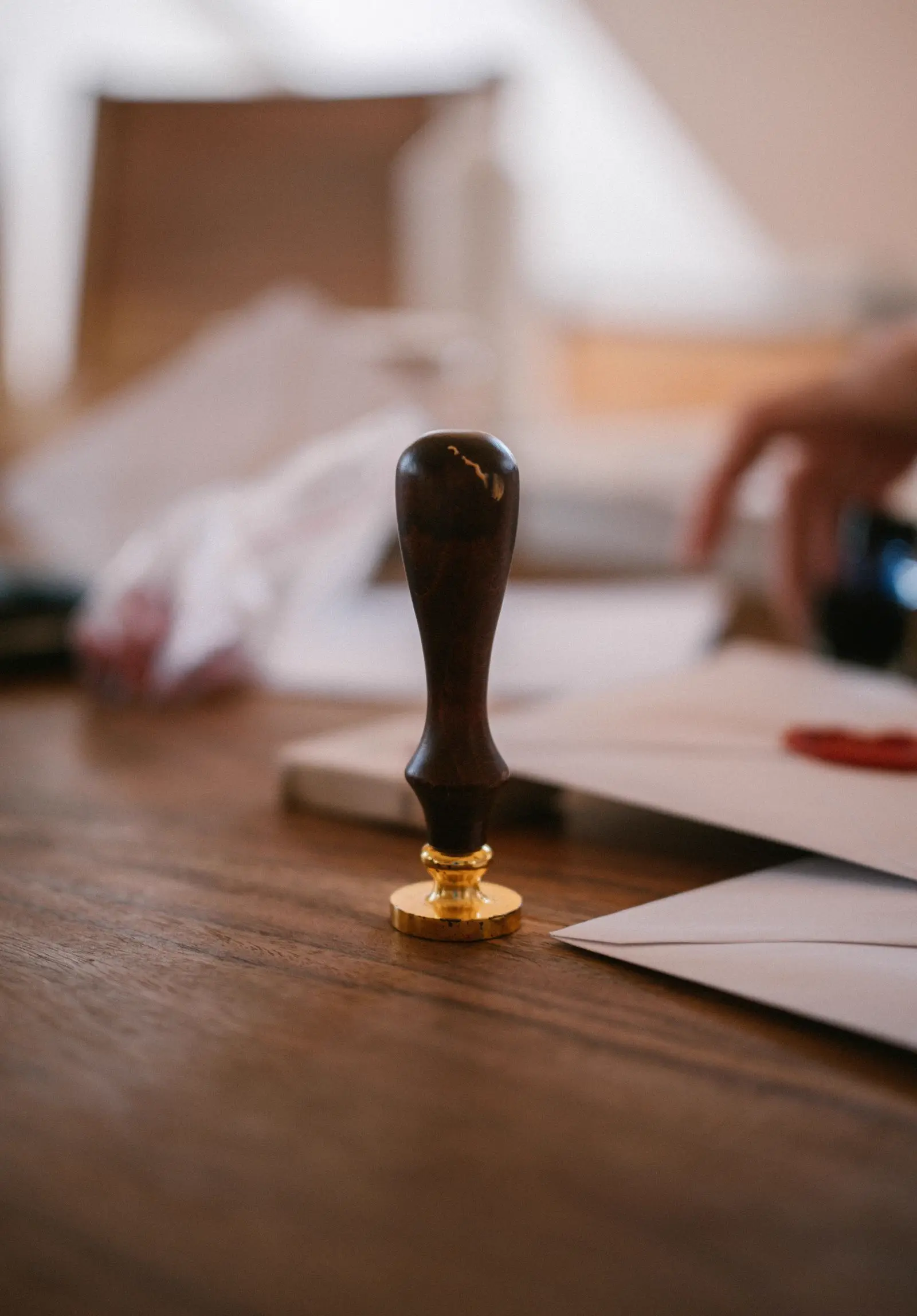 A wooden notary style seal stamp pressed beside a document